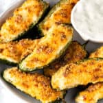 a plate of air fryer jalapeño poppers with a white dipping sauce