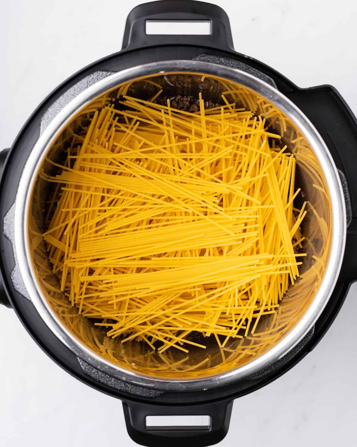 uncooked spaghetti pasta layered in criss cross pattern.