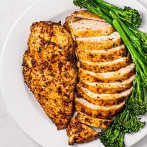 plate of air fryer chicken breasts with broccolini.