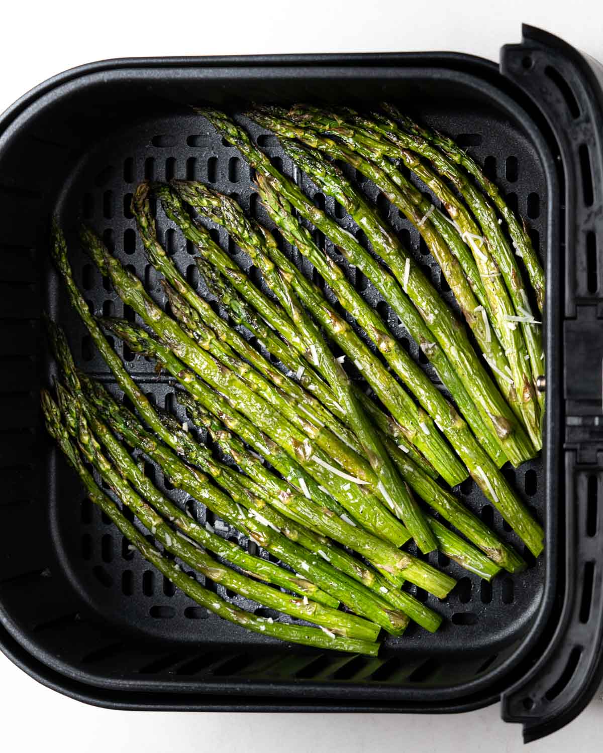 air fried asparagus in air fryer basket.