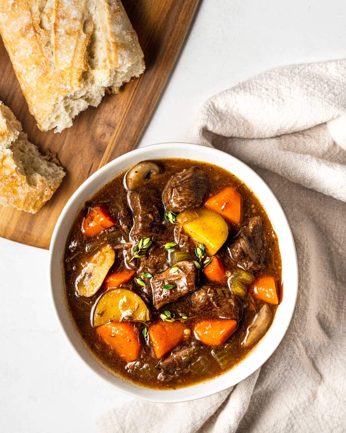 bowl of instant pot beef stew with bread on the side.