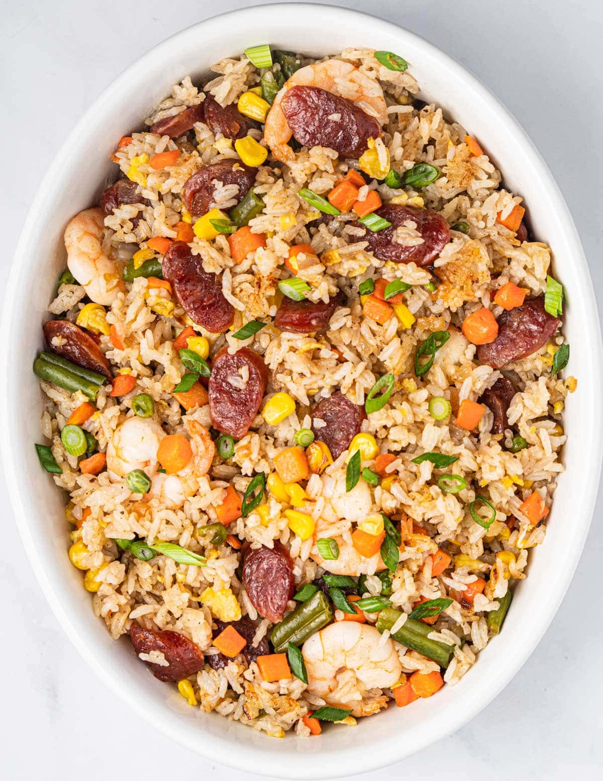 Serving bowl of Vietnamese Fried Rice with Chinese sausages, shrimp, and vegetables.