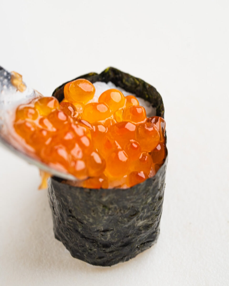 Spooning ikura (salmon roe) into the sushi boat.