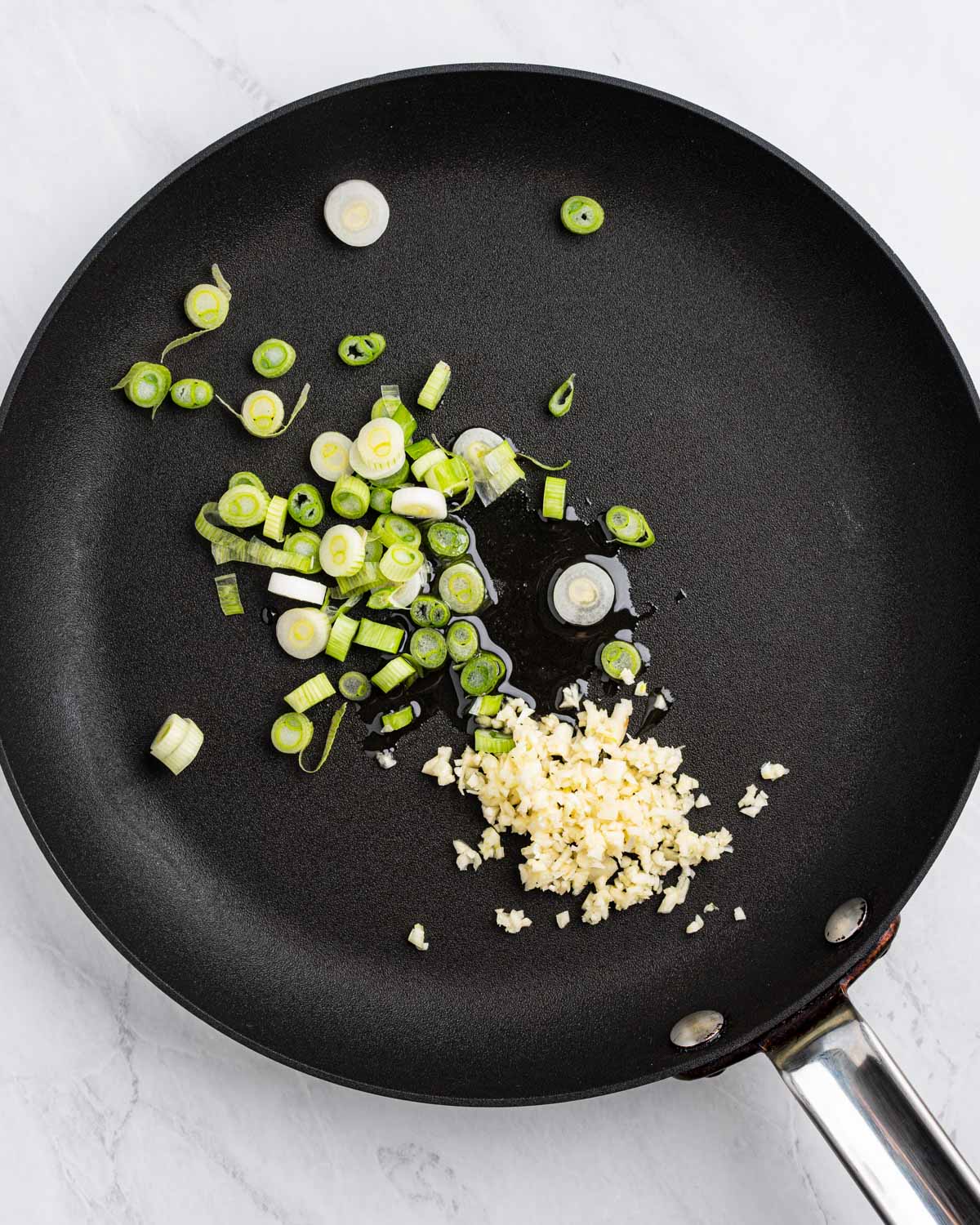 Pan with oil sliced green onions and minced garlic.
