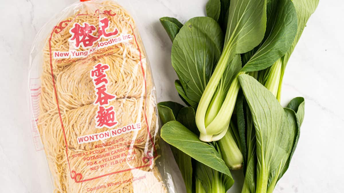bag of wonton noodles and raw baby bok choy.
